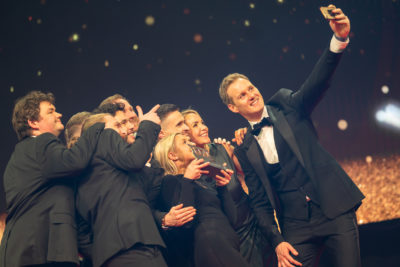 People taking selfie on stage at awards show